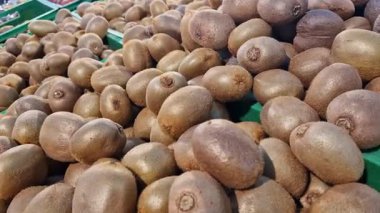 Markette ya da süpermarkette bir tezgahın üzerinde olgun kiviler. Markette bir yığın kivi var. Satılık Kivi meyveleri