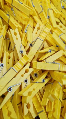 Sarı mandallar, üst manzara. Mandallar perakende satışı. Geçmişi. Bir sürü parlak plastik mandal. Plastik klipler kaotik bir şekilde duruyor.