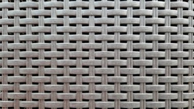 Çamaşır sepetinin dokunmuş plastik yüzeyinin yakın çekimi. Sentetik plastik desenlere yakın çekim. Plastik ev sepetlerinin dokunmuş yüzeylerinin yakın çekimi. Doku. Simetrik desenli plastik rattan