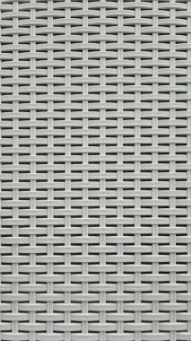 Çamaşır sepetinin dokunmuş plastik yüzeyinin yakın çekimi. Sentetik plastik desenlere yakın çekim. Plastik ev sepetlerinin dokunmuş yüzeylerinin yakın çekimi. Doku. Simetrik desenli plastik rattan