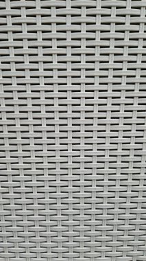 Çamaşır sepetinin dokunmuş plastik yüzeyinin yakın çekimi. Sentetik plastik desenlere yakın çekim. Plastik ev sepetlerinin dokunmuş yüzeylerinin yakın çekimi. Doku. Simetrik desenli plastik rattan
