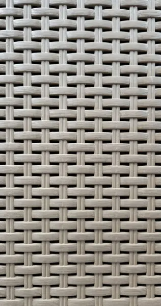 Çamaşır sepetinin dokunmuş plastik yüzeyinin yakın çekimi. Sentetik plastik desenlere yakın çekim. Plastik ev sepetlerinin dokunmuş yüzeylerinin yakın çekimi. Doku. Simetrik desenli plastik rattan