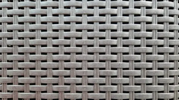 Çamaşır sepetinin dokunmuş plastik yüzeyinin yakın çekimi. Sentetik plastik desenlere yakın çekim. Plastik ev sepetlerinin dokunmuş yüzeylerinin yakın çekimi. Doku. Simetrik desenli plastik rattan