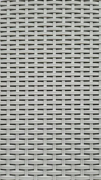 Çamaşır sepetinin dokunmuş plastik yüzeyinin yakın çekimi. Sentetik plastik desenlere yakın çekim. Plastik ev sepetlerinin dokunmuş yüzeylerinin yakın çekimi. Doku. Simetrik desenli plastik rattan