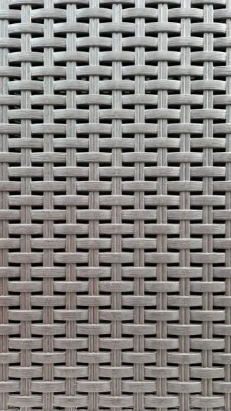 Çamaşır sepetinin dokunmuş plastik yüzeyinin yakın çekimi. Sentetik plastik desenlere yakın çekim. Plastik ev sepetlerinin dokunmuş yüzeylerinin yakın çekimi. Doku. Simetrik desenli plastik rattan