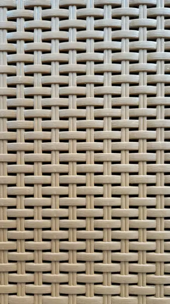 Çamaşır sepetinin dokunmuş plastik yüzeyinin yakın çekimi. Sentetik plastik desenlere yakın çekim. Plastik ev sepetlerinin dokunmuş yüzeylerinin yakın çekimi. Doku. Simetrik desenli plastik rattan