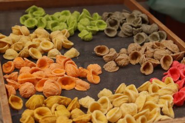 Orecchiette, bir çeşit İtalyan makarnası. İtalya 'da yaygın olan meşhur Apulian orekşisinin tanıtımı. Farklı aromalı taze makarna çeşitleri. Küçük kulaklı İtalyan makarnası.