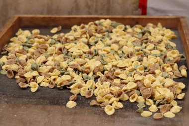 Orecchiette, bir çeşit İtalyan makarnası. İtalya 'da yaygın olan meşhur Apulian orekşisinin tanıtımı. Farklı aromalı taze makarna çeşitleri. Küçük kulaklı İtalyan makarnası.