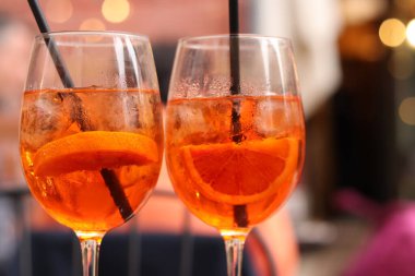 Aperol Spritz. Soğuk, ferahlatıcı alkollü kokteyl Aperol Spritz. Bulanık bir arka planda kokteyl yakın plan. Kamışlı bir bardakta alkollü içki. Geleneksel İtalyan alkollü içecek