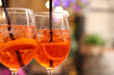 Aperol Spritz. Soğuk, ferahlatıcı alkollü kokteyl Aperol Spritz. Bulanık bir arka planda kokteyl yakın plan. Kamışlı bir bardakta alkollü içki. Geleneksel İtalyan alkollü içecek
