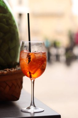 Aperol Spritz. Soğuk, ferahlatıcı alkollü kokteyl Aperol Spritz. Bulanık bir arka planda kokteyl yakın plan. Kamışlı bir bardakta alkollü içki. Geleneksel İtalyan alkollü içecek