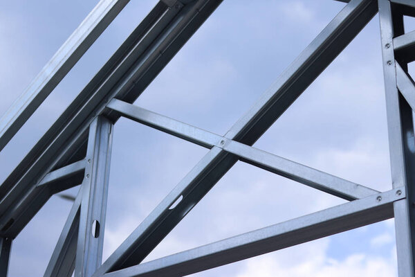 Легкие стальные тонкостенные конструкции. Рамки для складов, гаражей или домов. Структура стальной рамы для строительства против неба