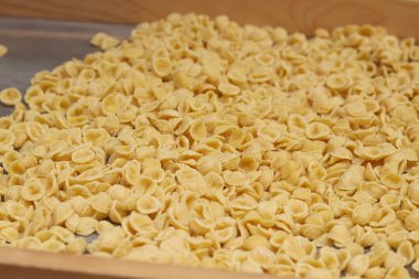Orecchiette, bir çeşit İtalyan makarnası. İtalya 'da yaygın olan meşhur Apulian orekşisinin tanıtımı. Taze makarna çeşitleri. Küçük kulaklı İtalyan makarnası. El yapımı orkestra makarna.