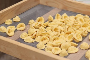 Orecchiette, bir çeşit İtalyan makarnası. İtalya 'da yaygın olan meşhur Apulian orekşisinin tanıtımı. Taze makarna çeşitleri. Küçük kulaklı İtalyan makarnası. El yapımı orkestra makarna.