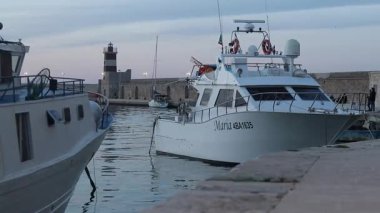 Monopoli, İtalya - 20 Nisan 2025: Eski limanda balıkçı tekneleri. Akşamları Apulia limanı. Deniz. Sudaki tekneler. Eski Porto Vecchio limanında balıkçı tekneleri. Balıkçılık endüstrisi