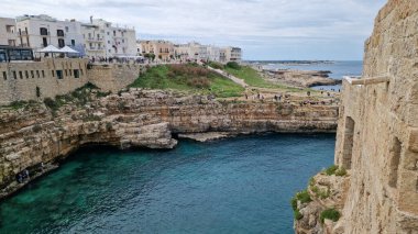 Polignano a Mare, İtalya - 13 Nisan 2025: Sudan şehir manzarası. Adriyatik Denizi 'nin deniz manzarası. Kumsal. Lama Monachile Körfezi manzarası. Apulia. Seyahat fotoğrafçılığı. Güzel manzara