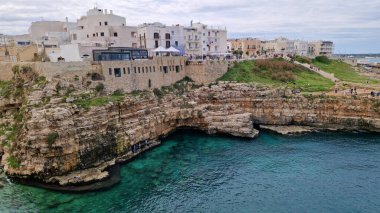 Polignano a Mare, İtalya - 13 Nisan 2025: Sudan şehir manzarası. Adriyatik Denizi 'nin deniz manzarası. Kumsal. Lama Monachile Körfezi manzarası. Apulia. Seyahat fotoğrafçılığı. Güzel manzara