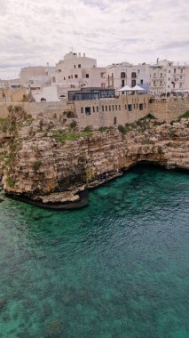 Polignano a Mare, İtalya - 13 Nisan 2025: Sudan şehir manzarası. Adriyatik Denizi 'nin deniz manzarası. Kumsal. Lama Monachile Körfezi manzarası. Apulia. Seyahat fotoğrafçılığı. Güzel manzara