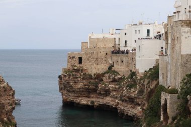 Polignano a Mare, İtalya - 13 Nisan 2025: Lama Monachile Körfezi manzarası. Apulia. Seyahat fotoğrafçılığı. Güzel manzara. Adriyatik Denizi 'nin deniz manzarası. Kumsal. Kaya kıyısı ve turkuaz su