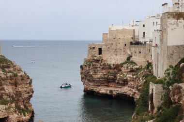 Polignano a Mare, İtalya - 13 Nisan 2025: Lama Monachile Körfezi manzarası. Apulia. Seyahat fotoğrafçılığı. Güzel manzara. Adriyatik Denizi 'nin deniz manzarası. Kumsal. Kaya kıyısı ve turkuaz su