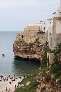 Polignano a Mare, İtalya - 13 Nisan 2025: Lama Monachile Körfezi manzarası. Apulia. Seyahat fotoğrafçılığı. Güzel manzara. Adriyatik Denizi 'nin deniz manzarası. Kumsal. Kaya kıyısı ve turkuaz su