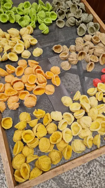 Kurutma sehpasında bir fresk. İtalya 'da yaygın olan ünlü Apulian orekşisinin tanıtımı. Taze makarna çeşitleri. Küçük kulaklı İtalyan makarnası. El yapımı orkestra makarna.