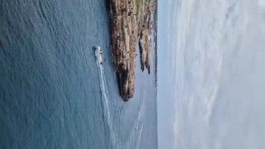 Polignano a Mare, İtalya - 13 Nisan 2025: Sudan şehir manzarası. Adriyatik Denizi 'nin deniz manzarası. Apulia. Kayaların altında bir sürü deniz mağarası var. Seyahat fotoğrafçılığı. Güzel manzara