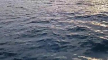 Tekneden deniz dalgalarının görüntüsü. Deniz. Deniz yürüyüşü. Dalgalarda yüzmek. Tekneden denizin yan yüzeyi. Su sıçrıyor. Seyahat videosu