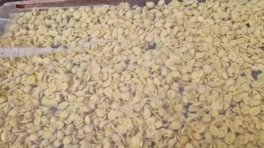 Kurutma sehpasında bir fresk. İtalya 'da yaygın olan ünlü Apulian orekşisinin tanıtımı. Taze makarna çeşitleri. Küçük kulaklı İtalyan makarnası. El yapımı orkestra makarna.