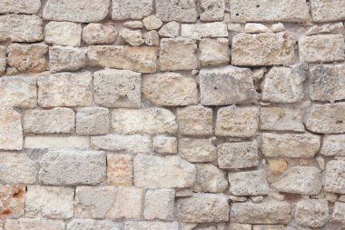 Eski bina duvarı. Geçmişi. Terk edilmiş taş duvar. Yüzeye çıkın. Eski bej rengi taş dokusu. Kireçtaşı desenli duvar, ön manzara.