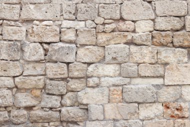 Eski bina duvarı. Geçmişi. Terk edilmiş taş duvar. Yüzeye çıkın. Eski bej rengi taş dokusu. Kireçtaşı desenli duvar, ön manzara.