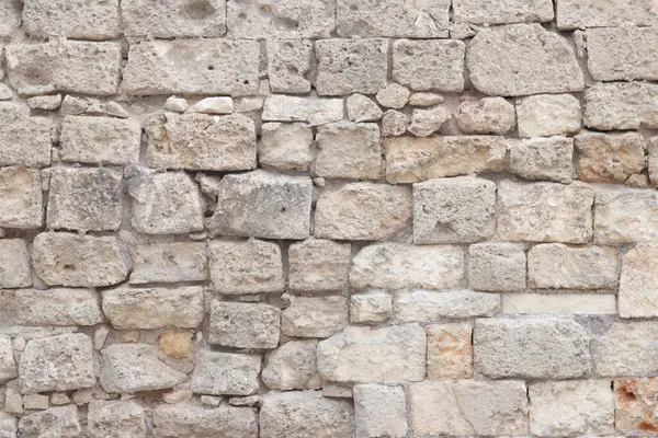 Eski bina duvarı. Geçmişi. Terk edilmiş taş duvar. Yüzeye çıkın. Eski bej rengi taş dokusu. Kireçtaşı desenli duvar, ön manzara.