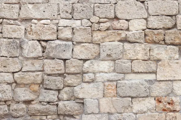 Eski bina duvarı. Geçmişi. Terk edilmiş taş duvar. Yüzeye çıkın. Eski bej rengi taş dokusu. Kireçtaşı desenli duvar, ön manzara.