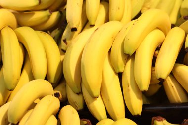 Yığınla olgun muz yığını. Süpermarkette satılan sarı muzlar. Yiyecekler. Bakkal geçmişi. Sokak pazarında olgunlaşmış muzlar.