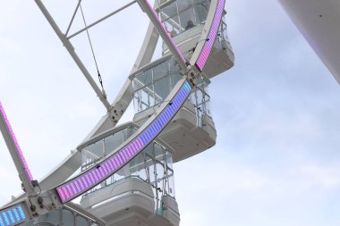 Bari, İtalya - 18 Nisan 2025: bulutlu bir gökyüzüne karşı dönme dolap. Eğlence parkı. Dönme dolapların yakın çekim görüntüleri.