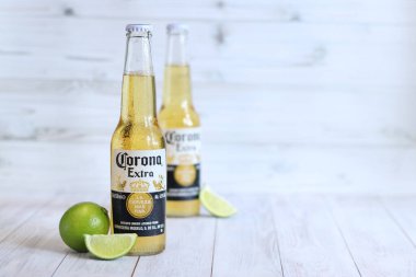 Kyiv, Ukrayna - 10 Mayıs 2025: Corona Ekstra limonlu bira, ahşap arka planda bira duruyor. Corona hafif bir bira. Limonlu şişe bira, yan görüş, boş yer. Soğuk içecek.