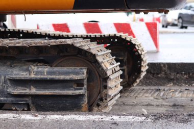 Kazı hattını kapatın. İnşaat kazıcısının bir kısmına yakın çekim, takip aracı. Şehirdeki tamirat işleri. Özel ekipman. İnşaat alanındaki ekipman. Ağır inşaat ekipmanları