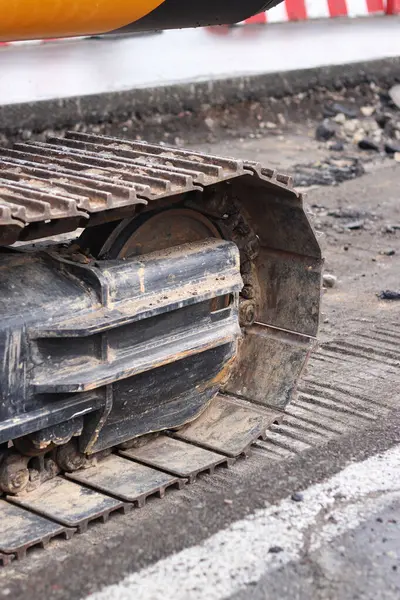 Kazı hattını kapatın. İnşaat kazıcısının bir kısmına yakın çekim, takip aracı. Şehirdeki tamirat işleri. Özel ekipman. İnşaat alanındaki ekipman. Ağır inşaat ekipmanları