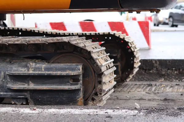 Kazı hattını kapatın. İnşaat kazıcısının bir kısmına yakın çekim, takip aracı. Şehirdeki tamirat işleri. Özel ekipman. İnşaat alanındaki ekipman. Ağır inşaat ekipmanları