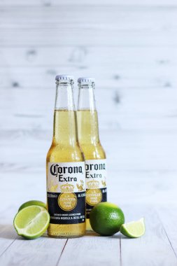 Kyiv, Ukrayna - 10 Mayıs 2025: Corona Ekstra limonlu bira, açık ahşap arka planda bira. Corona hafif bir bira. Limonlu şişe bira, yan görüş, boş yer. Tazeleyici içecek.