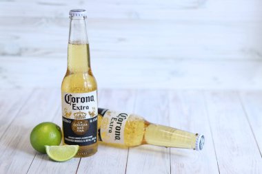 Kyiv, Ukrayna - 10 Mayıs 2025: Corona Ekstra limonlu bira, açık ahşap arka planda bira. Corona hafif bir bira. Limonlu şişe bira, yan görüş, boş yer. Tazeleyici içecek.