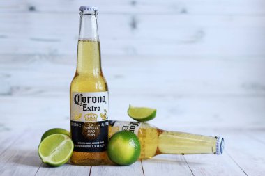 Kyiv, Ukrayna - 10 Mayıs 2025: Corona Ekstra limonlu bira, açık ahşap arka planda bira. Corona hafif bir bira. Limonlu şişe bira, yan görüş, boş yer. Tazeleyici içecek.