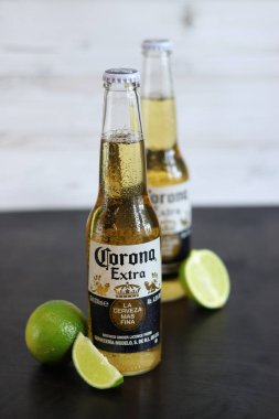 Kyiv, Ukrayna - 10 Mayıs 2025: Corona Ekstra limonlu bira, ahşap arka planda bira. Corona hafif bir bira. Limonlu şişe bira, yan görüş, boş yer. Tazeleyici içecek.