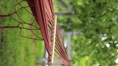 Hamak parktaki ağaçlara bağlı, yakın plan. Açık hava eğlencesi. Yaz ve eğlence konsepti. Bulanık doğa arka planında boş hamak. Açık hava eğlencesi. Sakinlik ve rahatlama sahnesi