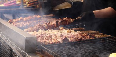 Şişler üzerinde Shashlik kömürlerin üstünde ızgarada pişirilir. Lezzetli ve sulu et. Terbiye edilmiş shaşlik kömürün üzerinde pişirilir. Yemek katı. Panayırda et pişirme süreci