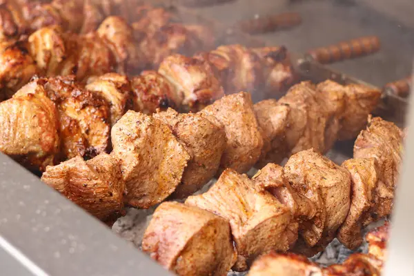 Şişler üzerinde Shashlik kömürlerin üstünde ızgarada pişirilir. Lezzetli ve sulu et. Terbiye edilmiş shaşlik kömürün üzerinde pişirilir. Yemek katı. Panayırda et pişirme süreci