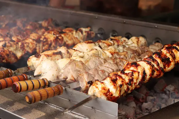 Şişler üzerinde Shashlik kömürlerin üstünde ızgarada pişirilir. Lezzetli ve sulu et. Terbiye edilmiş shaşlik kömürün üzerinde pişirilir. Yemek katı. Panayırda et pişirme süreci