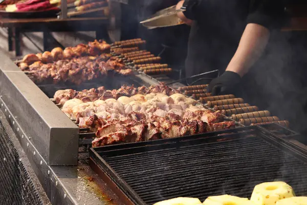 Şişler üzerinde Shashlik kömürlerin üstünde ızgarada pişirilir. Lezzetli ve sulu et. Terbiye edilmiş shaşlik kömürün üzerinde pişirilir. Yemek katı. Panayırda et pişirme süreci