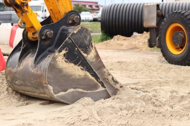 Kazı kovasına yakın çekim. Kazı makinesi araziyi düzleştiriyor. Şehirdeki tamirat işleri. Özel ekipmanlar. Sanayi, inşaat ve şehir projeleri. İnşaat alanındaki ekipman.