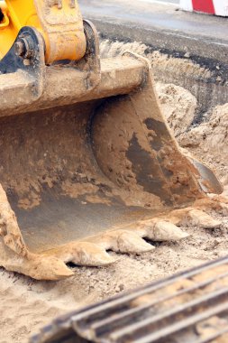 Kazı kovasına yakın çekim. Kazı makinesi araziyi düzleştiriyor. Şehirdeki tamirat işleri. Özel ekipmanlar. Sanayi, inşaat ve şehir projeleri. İnşaat alanındaki ekipman.
